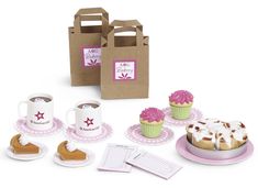 a table topped with cakes and cupcakes next to a bag filled with frosting