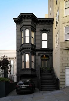 a car parked in front of a black house