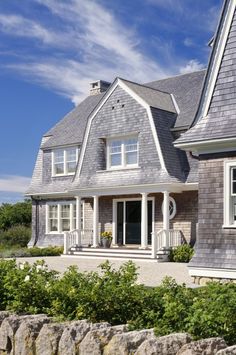 a large gray house with white trim and windows