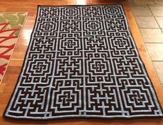 a black and white rug sitting on top of a wooden floor