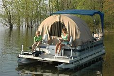 two people sitting on a pontoon in the middle of a body of water with trees around them