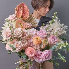 a woman holding a large bouquet of flowers