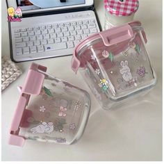 two plastic containers sitting on top of a table next to a laptop