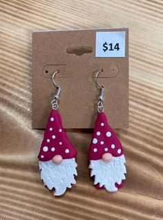 a pair of earrings with a red and white gnome face on it's ear