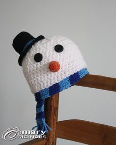 a crocheted snowman hat sitting on top of a wooden chair