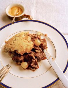 a white plate topped with a piece of pie next to a fork and cup of coffee