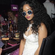 a woman sitting at a table with glasses on her face