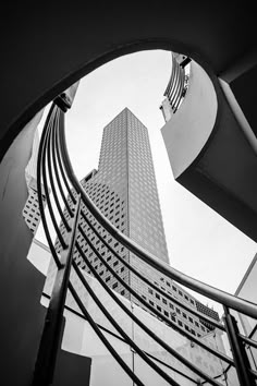 looking up at the top of a tall building from an escalator in front of it