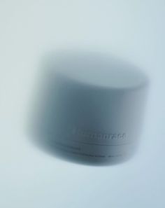 a blurry photo of a white container on a light background with the word lumentrac written in it