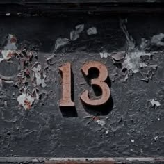 the number thirteen is written in rusted metal