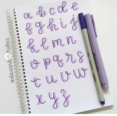 a notebook with some writing on it next to a pair of purple markers and a pen