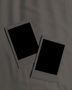 two black and white polaroid frames laying on a bed