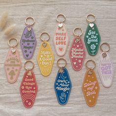 six different colored key chains with sayings on them