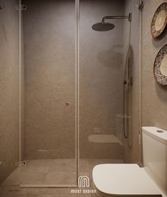 a bathroom with a walk in shower next to a toilet