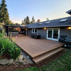 a backyard with a deck and patio furniture