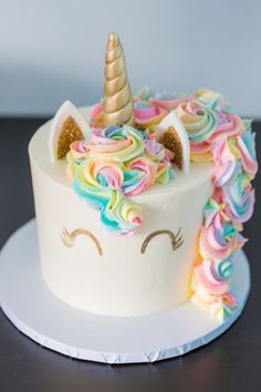 a birthday cake with a unicorn horn and rainbow icing