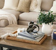 a coffee table topped with books and a vase filled with flowers