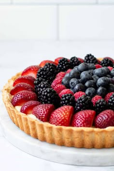 a pie topped with fresh berries and blueberries