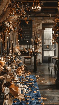 a long table with candles and flowers on it in a room filled with tables, chairs and other decorations