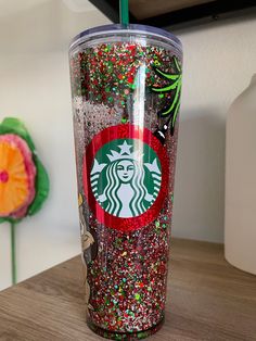 the starbucks cup is decorated with colorful sprinkles and glittery decorations on it