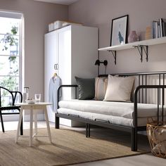 a living room filled with furniture next to a white table and chair in front of a window