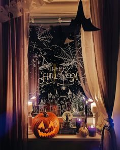 a window decorated for halloween with pumpkins and candles