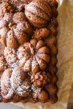 a pastry with powdered sugar on it sitting on top of a piece of paper