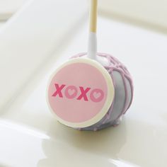 a lollipop with the word xoxo on it sitting on a table