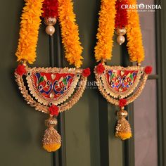 two colorful hanging decorations with tassels and beads on display in front of a door