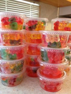 several plastic containers filled with gummy bears on top of a counter