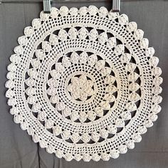 a crocheted doily hanging on a wall