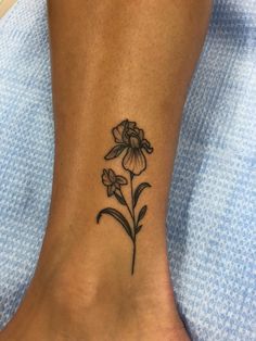 a flower tattoo on the foot of a woman's leg, with flowers in it