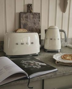 a toaster sitting on top of a counter next to an open book