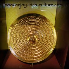 a gold plate is on display in a glass case