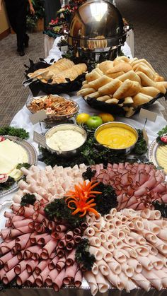 a buffet table filled with different types of food and dipping sauces on top of it