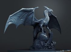 a statue of a blue dragon sitting on top of a piece of rock in front of a dark background