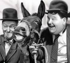 three men in suits and hats are laughing with a horse