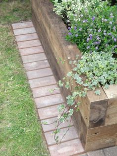 a wooden planter filled with lots of flowers