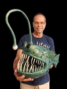 a man is holding a fake alligator head