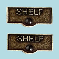 two metal signs with words on them that say shelf and shell against a blue background