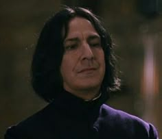 a close up of a person with long hair and wearing a black coat, looking off to the side