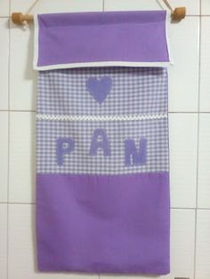 a purple and white towel hanging on a wall next to a tiled floor with the word pam printed on it