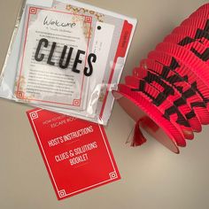 a red hat with black letters on it sitting next to a book and some other items