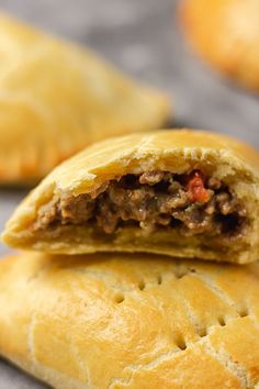 two pastries with meat in them sitting on a table