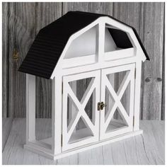 a white and black birdhouse on top of a wooden table