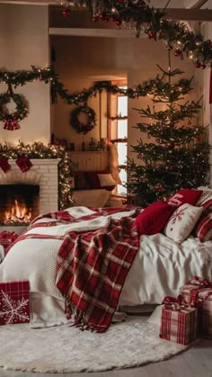 a bedroom decorated for christmas with red and white plaid bedding, presents on the floor