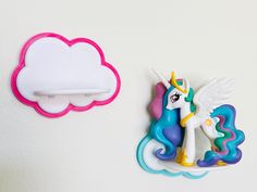 two little pony brooches sitting next to each other on a white surface,