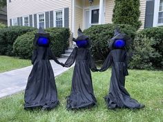 three people dressed in black and blue holding hands