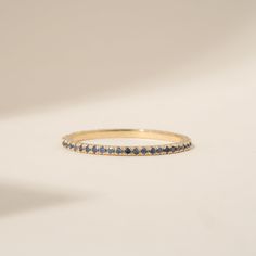 a yellow gold ring with blue sapphires on the inside, set against a white background