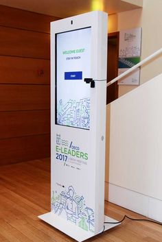 an electronic sign stands on the floor in front of a staircase with wood paneling